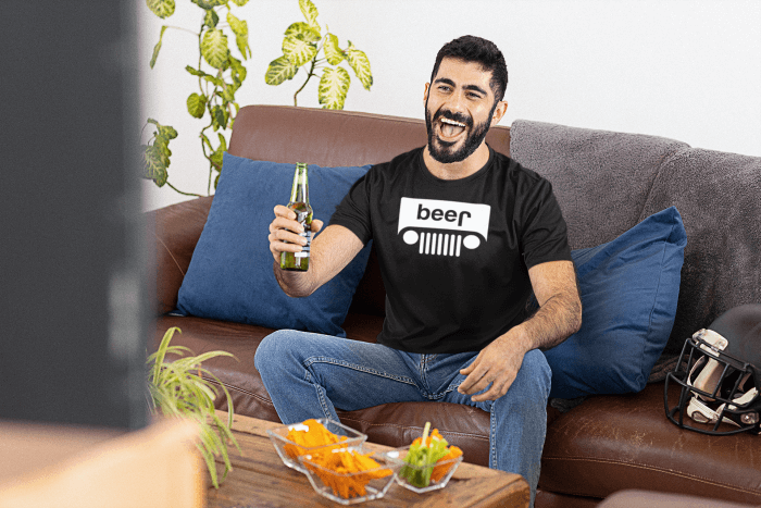 Football fan watching the big game at home in a beer jeep shirt