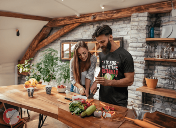 bearded-man-cutting-vegetables-with-his-girlfriend-wearing-vegetarian-t-shirt