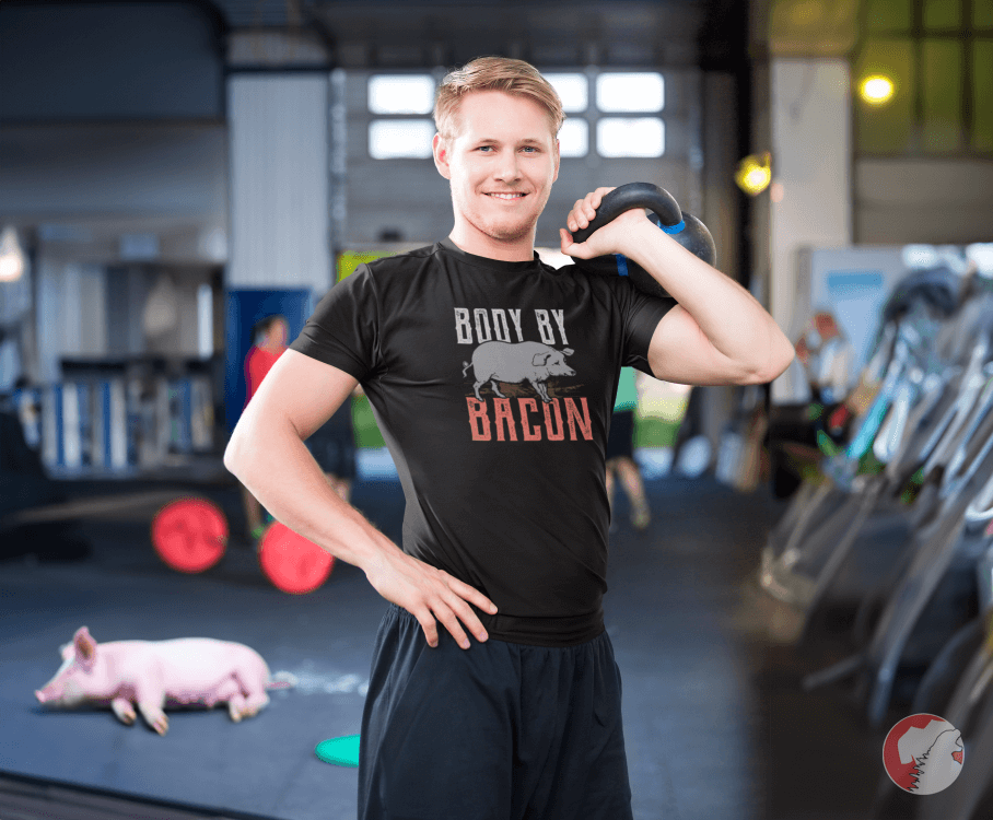 Delighted-man-lifting-weights-at-gym-wearing-body-by-bacon-shirt